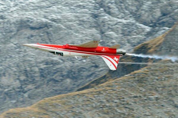 Avión blanco y rojo en el fondo de la cordillera