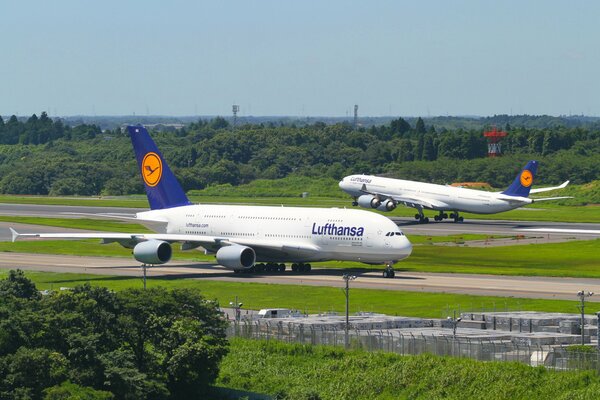 Deux avions blancs se tiennent sur la piste