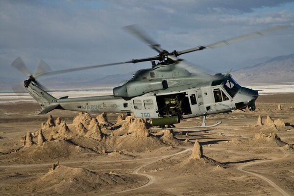 Helicóptero multipropósito Bell ah vuela sobre las montañas