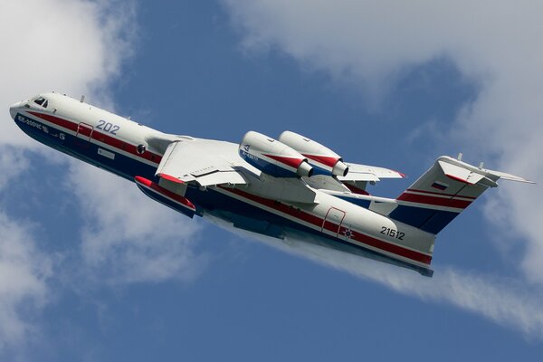 Un avion blanc avec une bande bleue et rouge vole dans le ciel