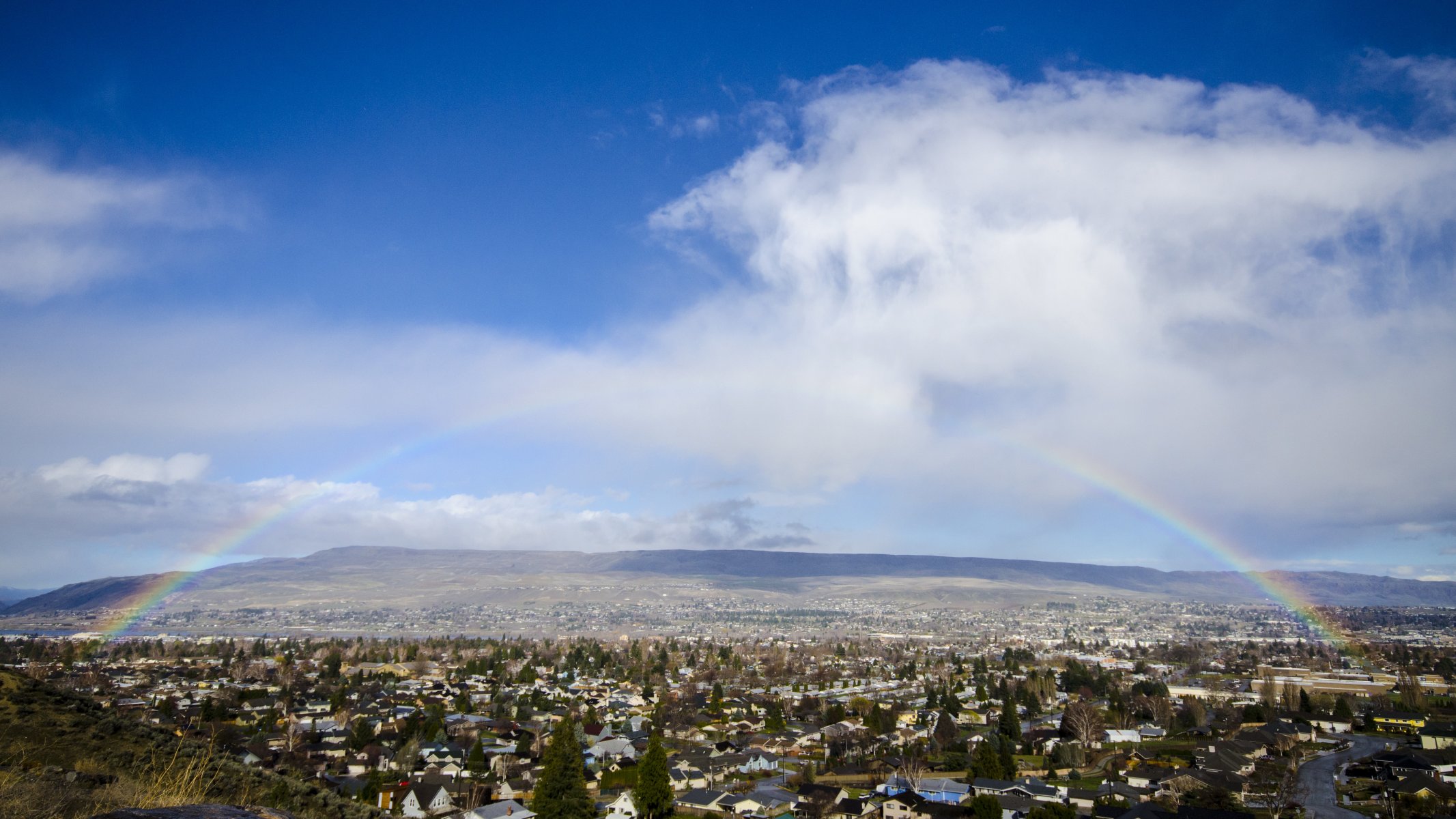 valle colline case alberi arcobaleno cielo nuvole