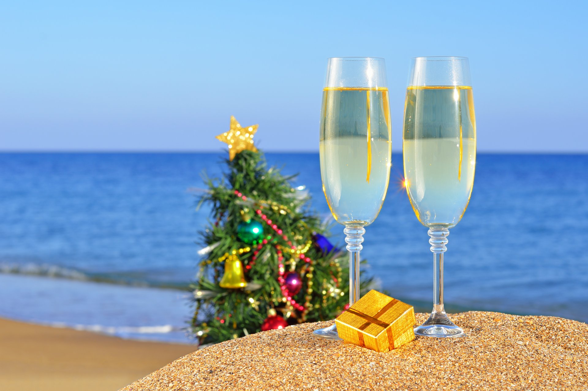 vacaciones año nuevo mar océano navidad playa arena copas de vino regalo juguetes