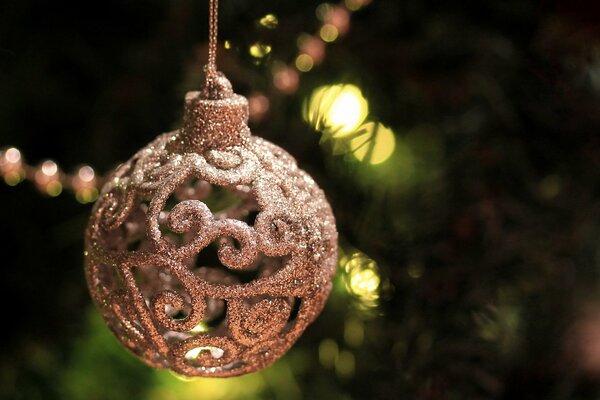 Christmas ball on the background of a Christmas tree with burning lights