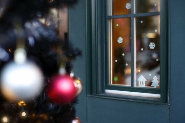 Toys on the Christmas tree and snowflakes on the window