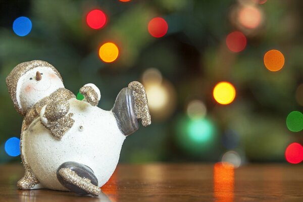 Pupazzo di neve giocattolo di Natale sullo sfondo di un albero di Natale decorato