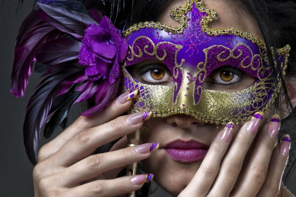 A girl with a beautiful mask on which feathers