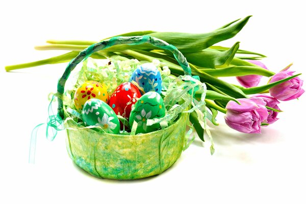 A basket with Easter eggs and a bouquet of tulips