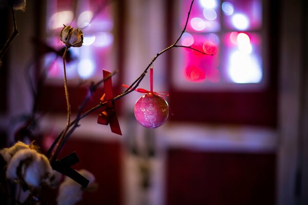 A branch with Christmas tree toys on the background of the door