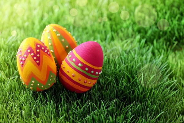 Bright Easter eggs lie on the green grass