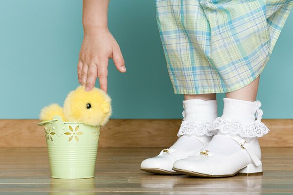 Niña con calcetines blancos se acerca a vedёrku