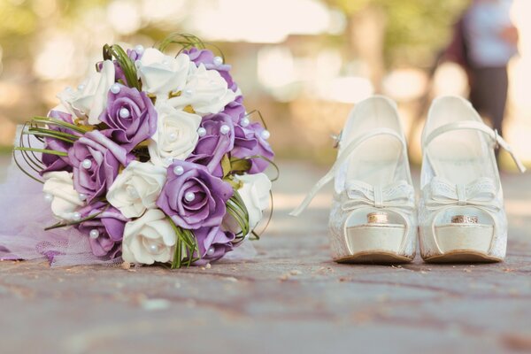 Wedding bouquet and shoes on paving stones