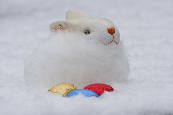 Conejito de Pascua con huevos en la nieve