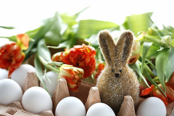 Easter bunny among flowers and eggs