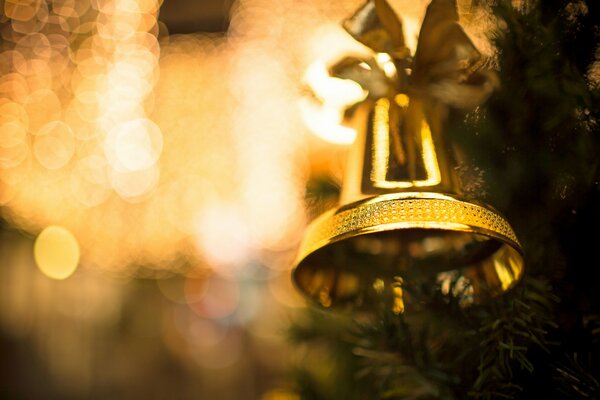 A large golden bell hanging on the Christmas tree