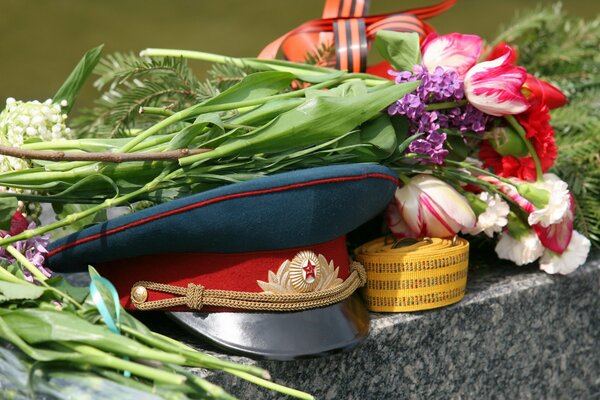 Blumen und Schirmmütze am 9. Mai