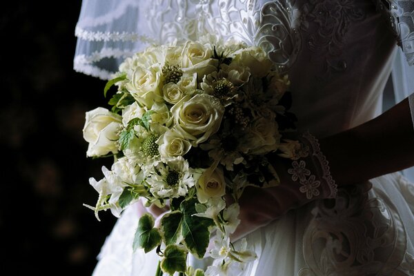 Bouquet in the hands of the bride at the wedding