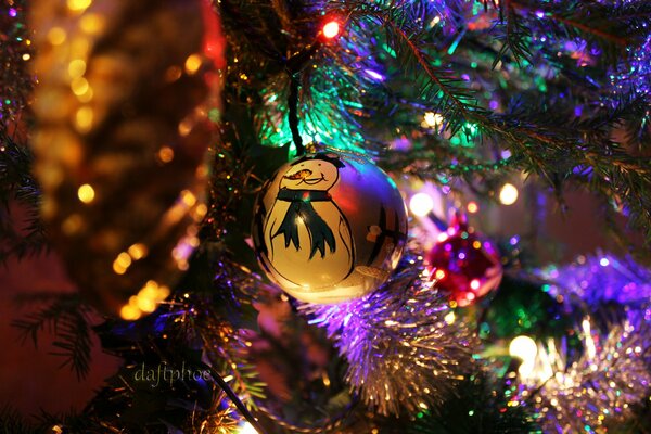 Snowman in the rays of lights on the Christmas tree