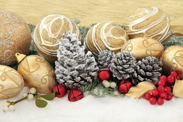 Golden Christmas toys, cones and bells in the snow