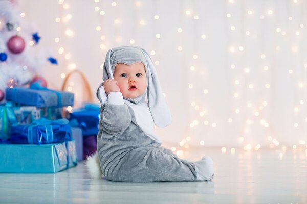 Baby im Hasenkostüm am Weihnachtsbaum