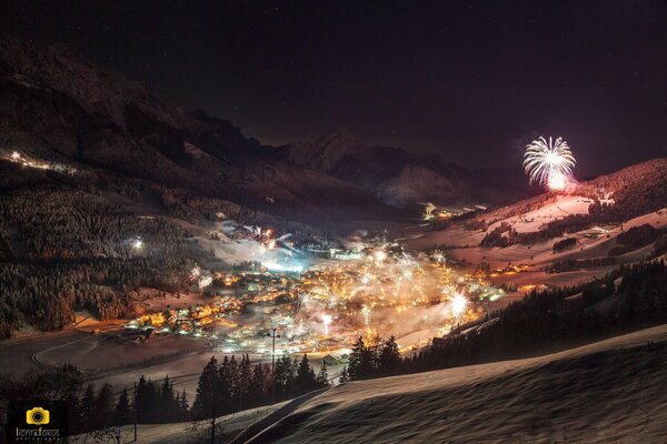 Winter night city with lights and fireworks