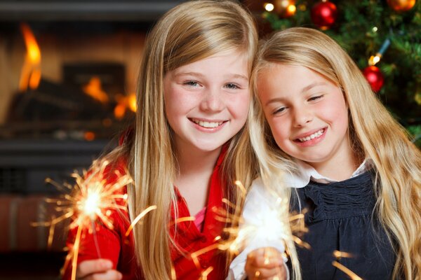 Two girls, smiling, holding sparklers