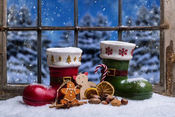 Santa Claus boots and Christmas decor on the background of the window