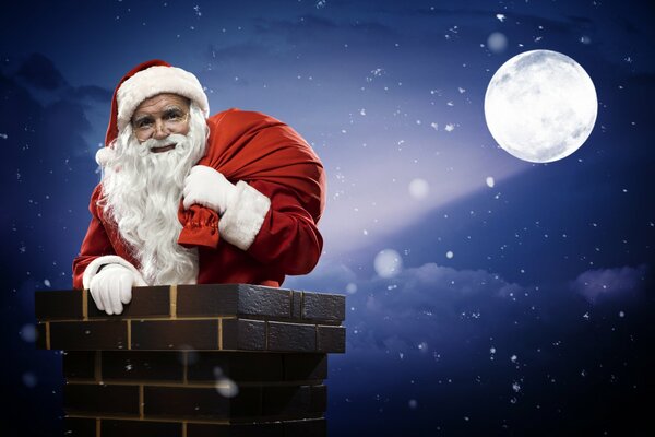 Santa Claus avec un sac de cadeaux à la pleine lune