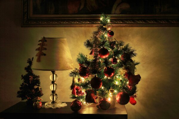 Albero di Natale nelle luci nella stanza sul comodino