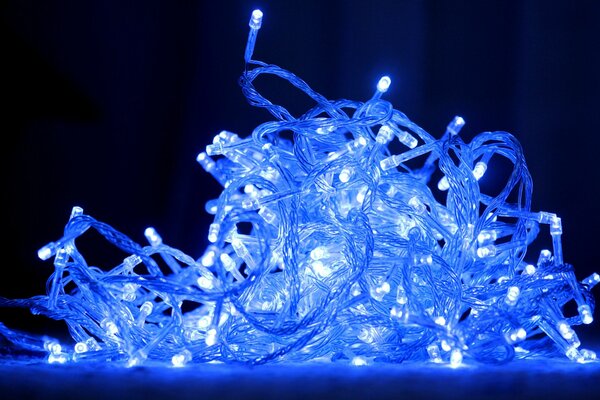 The garland shines blue on a black background