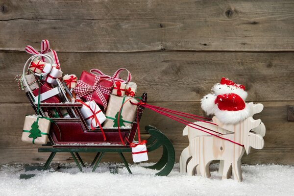 Hölzerne Rentiere und Schlitten mit Geschenken