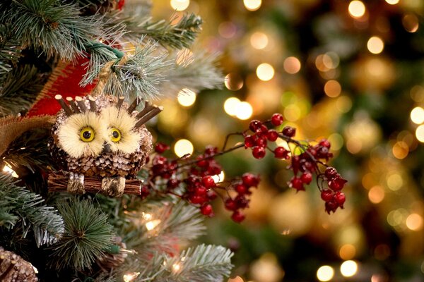 Juguetes de árbol de Navidad en una rama con un búho