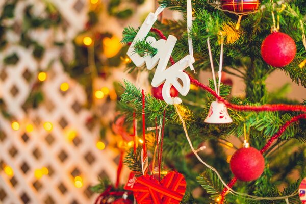 El árbol de Navidad está decorado con juguetes rojos con cuentas y corazones