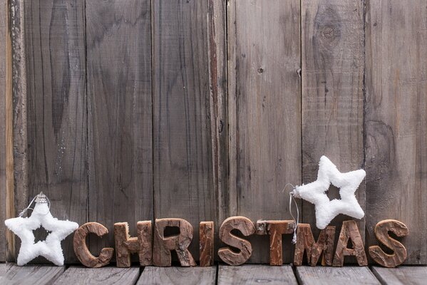 The inscription Christmas with two white snow stars