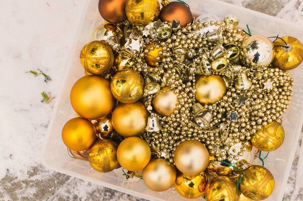 A box with Christmas tree golden balls and beads