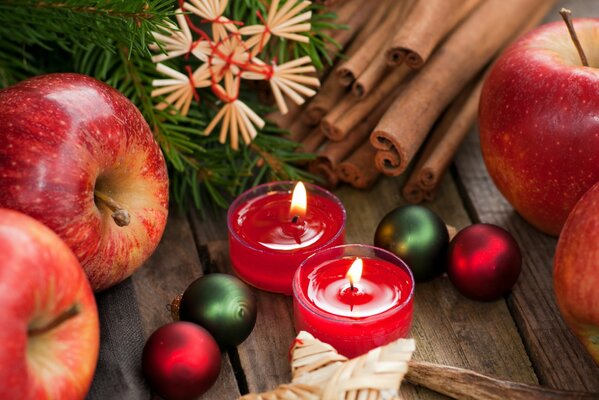 Candele rosse insieme al simbolismo del Natale, alla cannella e alle decorazioni natalizie