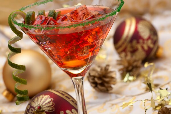 Cocktail on the background of Christmas decorations, cones and artificial snow