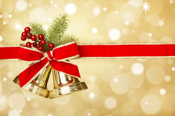 Christmas decoration bells with a red ribbon, berries and a fir twig