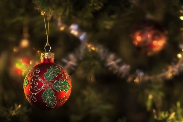 New Year s red toy with a pattern hanging on the Christmas tree