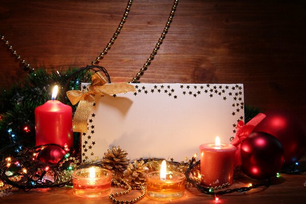 Candles, Christmas decorations and a card on the table