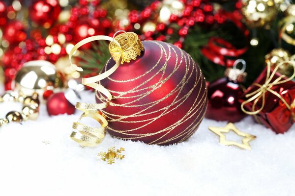 Bola de Navidad roja en la nieve de cerca