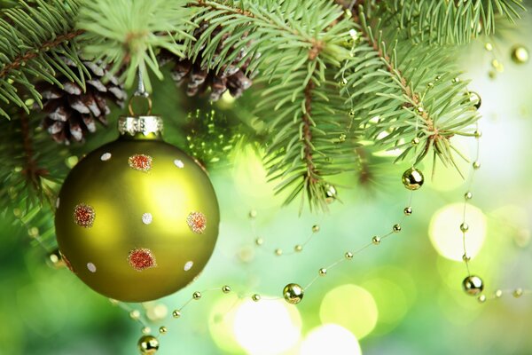 Boule verte avec des perles sur une branche d épinette