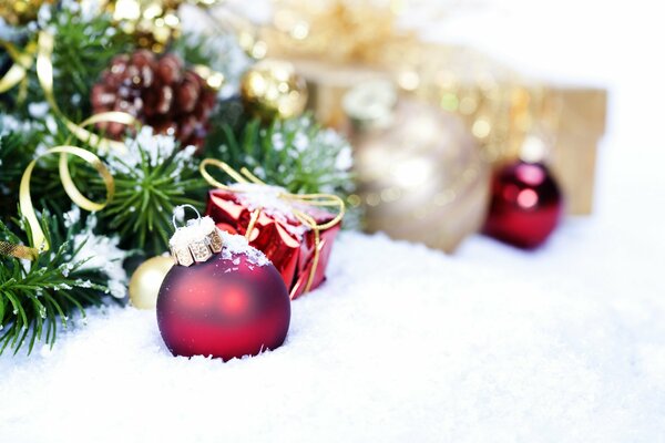 Christmas toys are lying on the snow near the Christmas tree