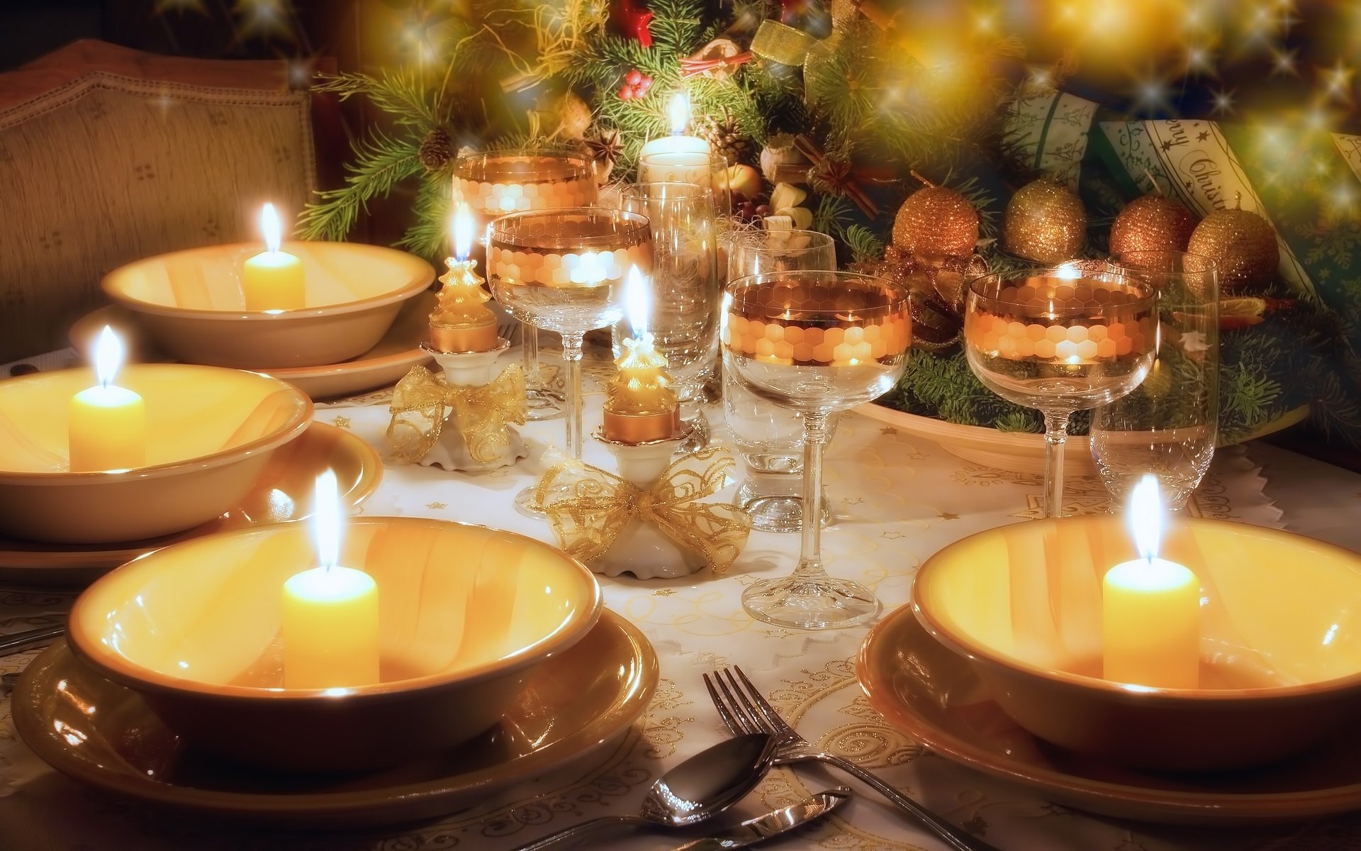 impostazione della tavola capodanno decorazione tavola stoviglie beige bicchieri bicchieri da vino dorati candele archi albero di natale natale