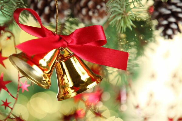 Decoration golden bells with a red bow on the Christmas tree