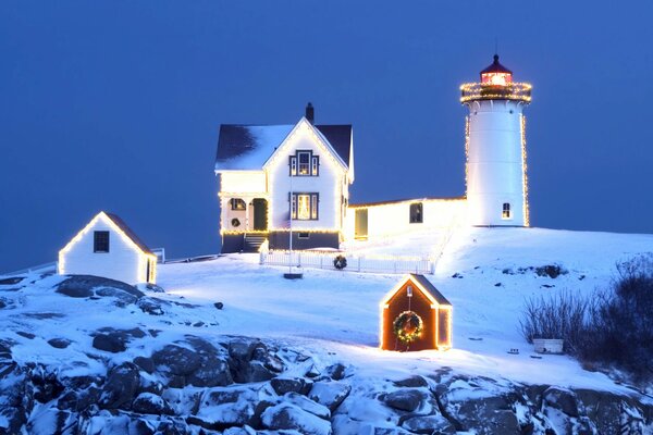 Christmas lights garlands on the snow lighthouse