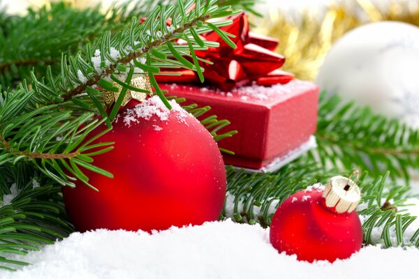 Décoration et boîte-cadeau sur la neige sous une branche de sapin