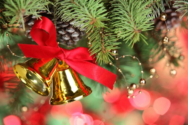 Dekoration von goldenen Glocken mit roter Schleife am Weihnachtsbaum