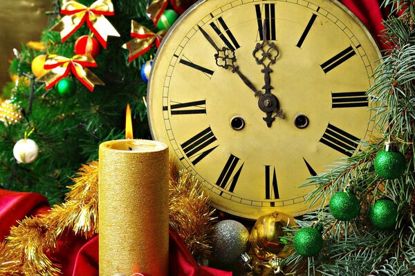 New Year s candle and clock in New Year s decoration of fir branches in colorful bows and balls