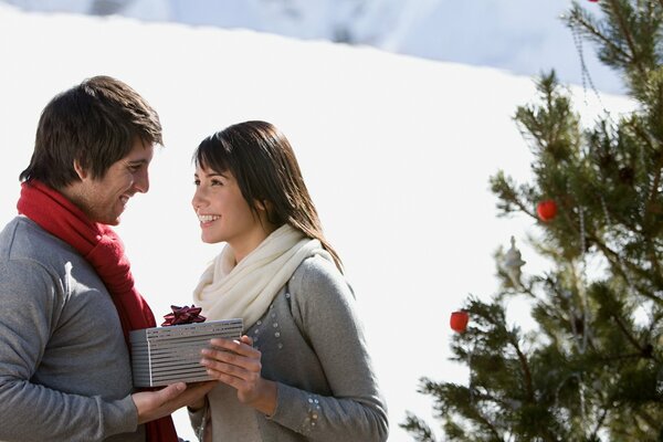 Happy guy and girl give each other gifts