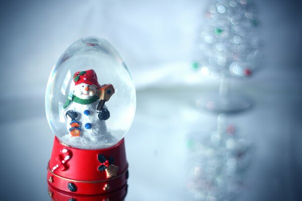 Boule de verre de bonhomme de neige sur la table en verre